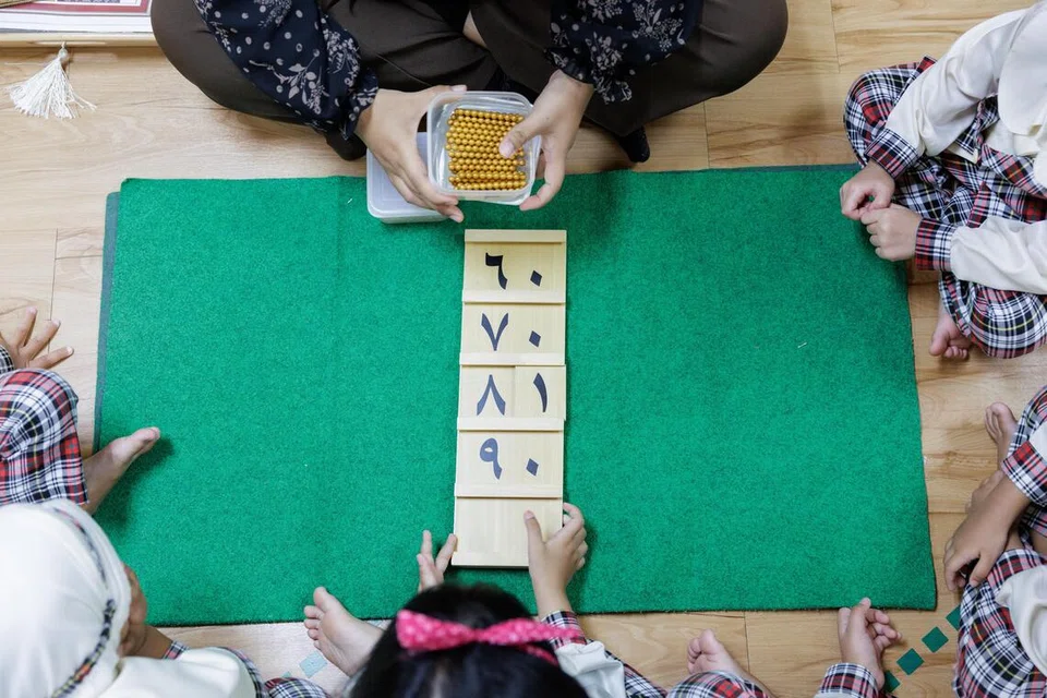 Murid-murid Hanis Montessori mengikuti aktiviti pembelajaran menggunakan bahan Montessori sambil menerapkan bahasa Arab.