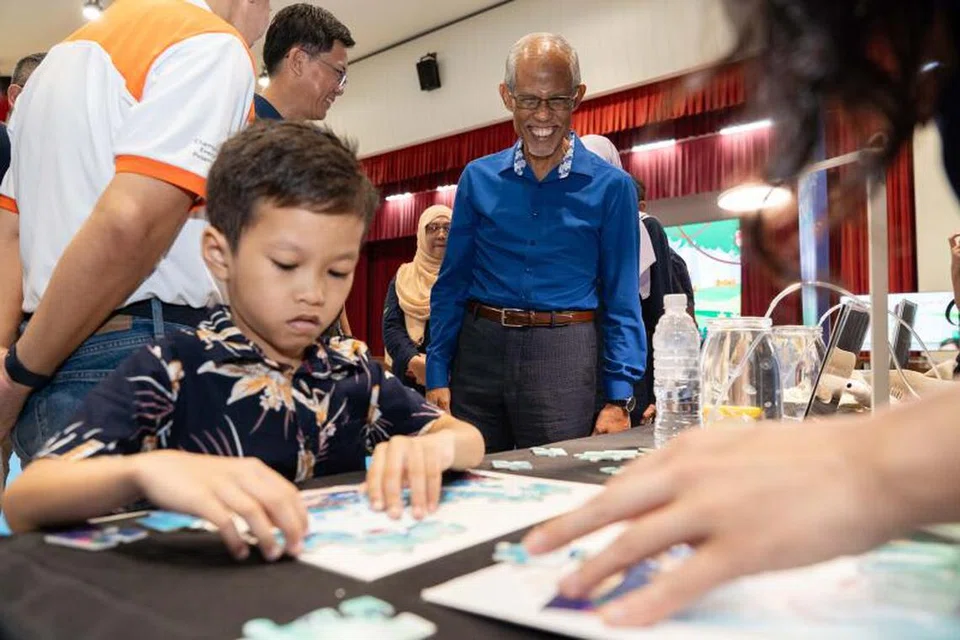 Menteri Pembangunan Sosial dan Keluarga, Encik Masagos Zulkifli Masagos Mohamad (tengah), memerhatikan seorang kanak-kanak yang sedang menyelesaikan ‘jigsaw puzzle’ di majlis pelancaran inisiatif Green Adventures oleh KidSTART dan SP Group pada 2 Mac.