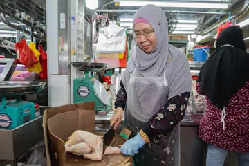 Cik Roslina Onn, 57 tahun, peniaga gerai ‘Jaafar’, mengusahakan perniagaan menjual ayam di Pasar Geylang Serai bersama anak-anaknya selama lebih 10 tahun. 