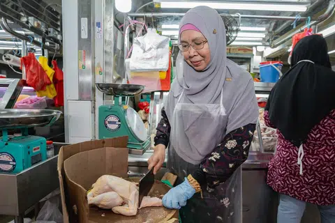Cik Roslina Onn, 57 tahun, peniaga gerai ‘Jaafar’, mengusahakan perniagaan menjual ayam di Pasar Geylang Serai bersama anak-anaknya selama lebih 10 tahun. 