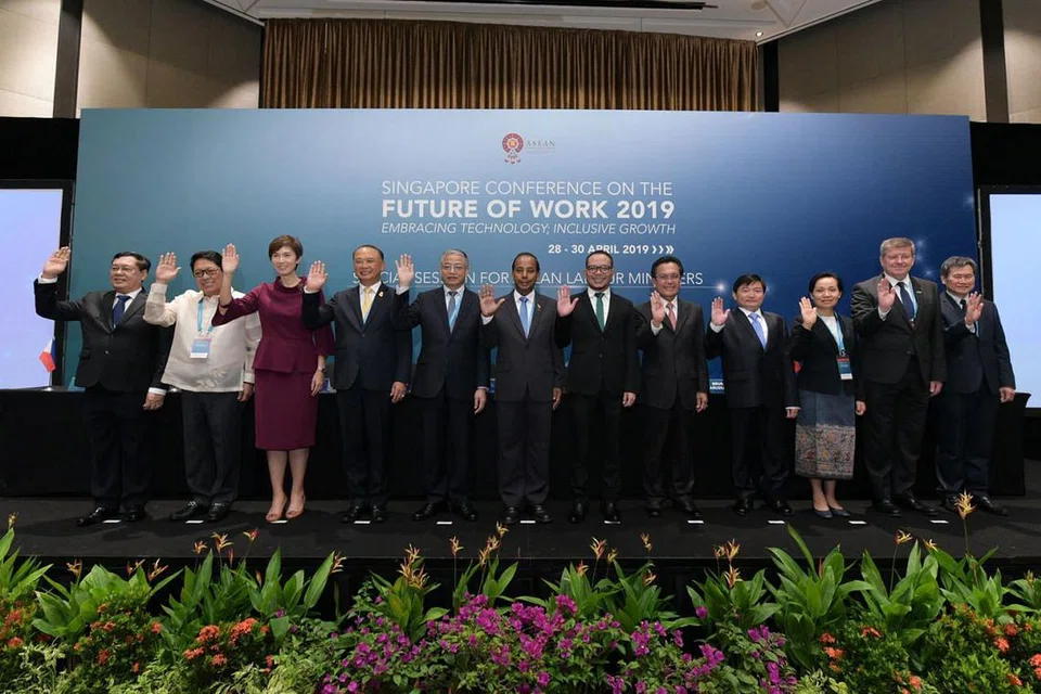 PERIKATAN DEMI MASA DEPAN: Menteri Tenaga Manusia Asean termasuk Cik Josephine Teo (tiga dari kiri) bersama Pengarah Umum ILO, Encik Guy Ryder (dua dari kanan), dalam sidang pekerjaan di Pusat Konvensyen Raffles City semalam. - Foto MOM