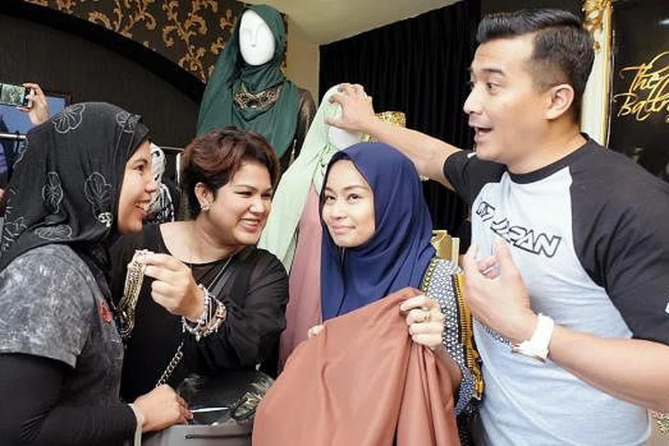 SERONOK BERBELANJA: Pengalaman membeli baju Raya pastinya lebih manis apabila anda dilayan oleh selebriti terkenal Aaron Aziz (kanan) yang membantu isterinya, Diyana Halik (bertudung biru), menjual busananya dengan jenama diyanaxfatimah. Diyana bergabung dengan jurumekap popular, Fatimah Mohsin (di kanan Diyana) bagi koleksi ini. - Foto ZAKI RAZALI PHOTOGRAPHY