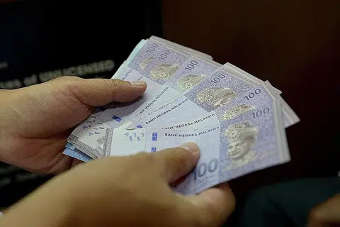 RAMAI TUKAR DUIT: Dolar Singapura mencapai RM3.05 semalam disebabkan permintaan lemah bagi mata wang Malaysia sedang harga minyak merudum. - Foto fail