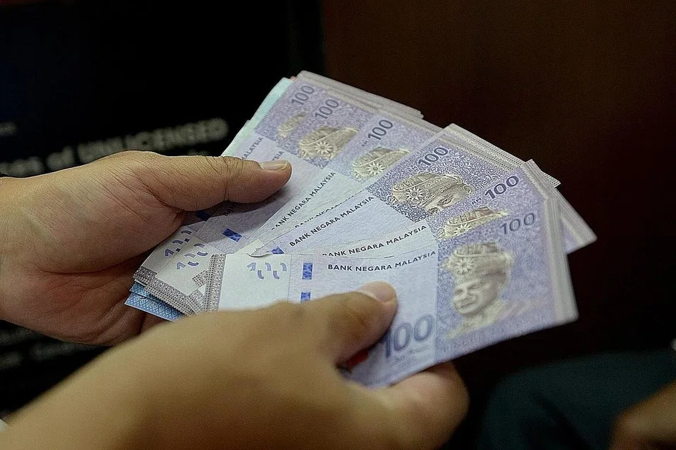 RAMAI TUKAR DUIT: Dolar Singapura mencapai RM3.05 semalam disebabkan permintaan lemah bagi mata wang Malaysia sedang harga minyak merudum. - Foto fail