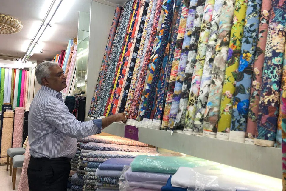 TAWAR KHIDMAT ALTERNATIF: Dengan sebanyak 70 peratus pelanggannya dari luar negara seperti Malaysia, Brunei, Indonesia dan Eropah, pemilik Osman Silk House, Encik Mohamed Anis Osmanbhoy (kiri), berkongsi beliau menawarkan khidmat kourier bagi kain-kainnya. - Foto BH oleh NATASHA MUSTAFA