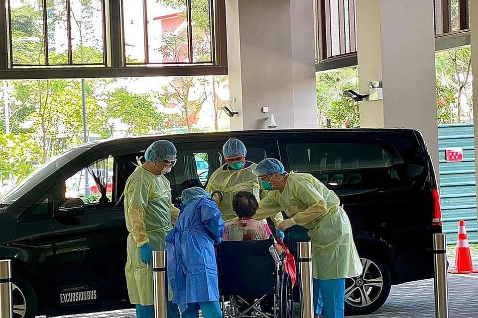 HULURKAN BANTUAN: Kakitangan di kemudahan rawatan masyarakat (CTF) pertama Singapura di Tampines menerima seorang pesakit warga emas yang dijangkiti Covid-19. Kemudahan itu, yang dikendalikan Woodlands Health, disediakan bagi pesakit yang secara umumnya dalam keadaan baik tetapi mempunyai masalah kesihatan lain yang memerlukan pemantauan dekat. - Foto WOODLANDS HEALTH