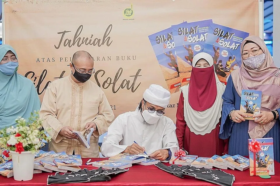 SOKONG: Sebahagian daripada pelajar dan ahli keluarga Ustaz Mohamad Bahrul-Ulum Buang (duduk) yang hadir ke pelancaran bukunya - Silat & Solat semalam. - Foto BH oleh NUR DIYANA TAHA