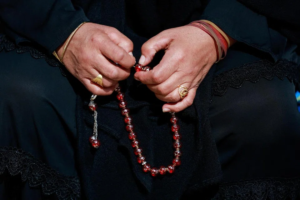 Gambaran seorang wanita sedang berzikir.