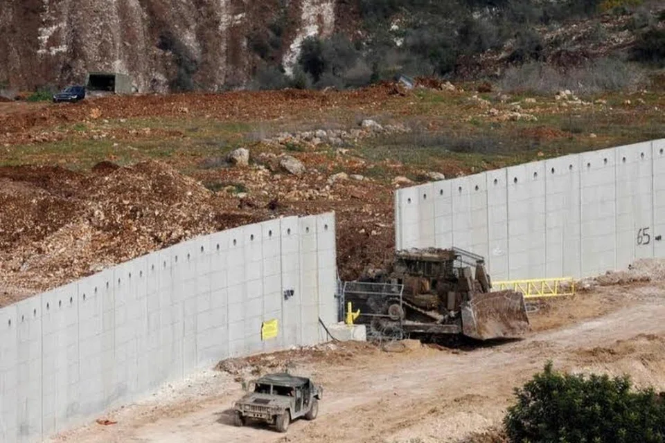 Kenderaan tentera Israel melintasi tembok di sempadan antara Israel dengan perkampungan Dhayra di Lebanon pada 17 Februari.