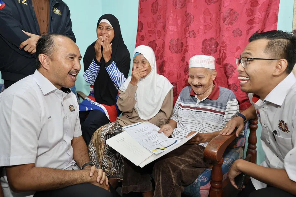 Pengerusi Jawatankuasa Perumahan dan Kerajaan Tempatan Johor, Datuk Mohd Jafni Md Shukor (kiri), menyerahkan sijil tawaran Rumah Kasih Johor kepada sebuah keluarga di Kulai, Johor.