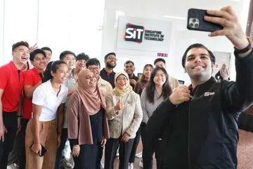 LAWATAN: Presiden Halimah Yacob (barisan depan, tiga dari kanan) bersama beberapa pelajar daripada SIT yang terlibat dalam inisiatif kesihatan mental di universiti itu pada Rabu pagi.