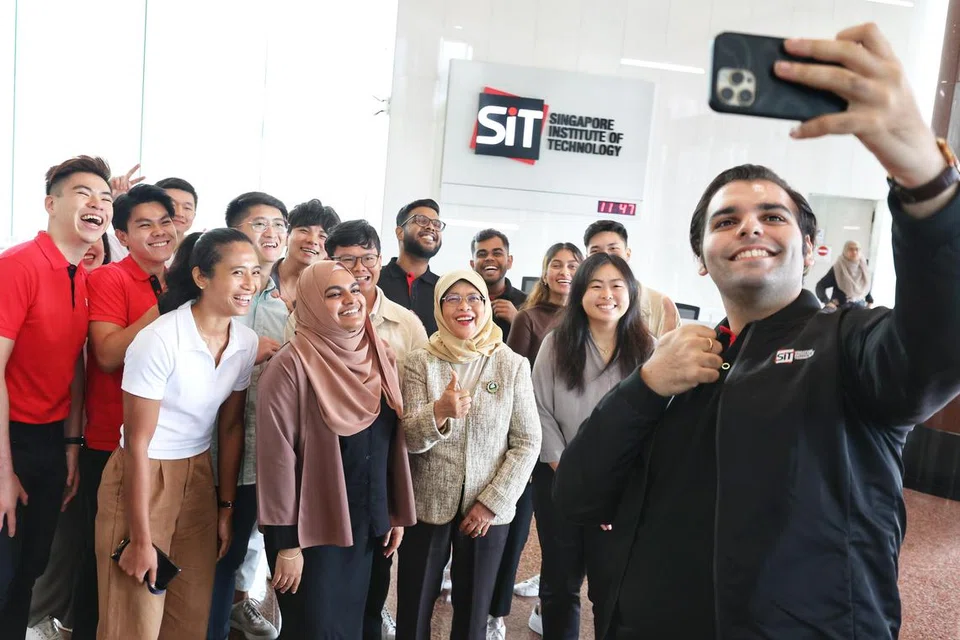 LAWATAN: Presiden Halimah Yacob (barisan depan, tiga dari kanan) bersama beberapa pelajar daripada SIT yang terlibat dalam inisiatif kesihatan mental di universiti itu pada Rabu pagi.