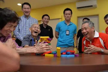 MASYARAKAT UNTUK SEMUA: Encik Lee (kanan, duduk) berkata langkah membangunkan kemudahan penjagaan warga lanjut usia di kejiranan adalah penting bagi mewujudkan sebuah masyarakat untuk semua golongan usia. - Foto THE STRAITS TIMES