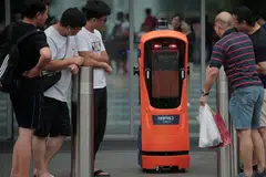 ERA TEKNOLOGI DAN AUTOMASI: Pengunjung di Jewel Lapangan Terbang Changi melihat secara dekat robot autonomi kendalian Certis Cisco pada 4 Jun lalu. Menurut penulis, rakyat Singapura perlu belajar untuk bekerja bersama robot untuk melangkah lebih jauh ke hadapan. - Foto BH oleh JASON QUAH
