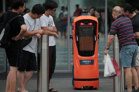 ERA TEKNOLOGI DAN AUTOMASI: Pengunjung di Jewel Lapangan Terbang Changi melihat secara dekat robot autonomi kendalian Certis Cisco pada 4 Jun lalu. Menurut penulis, rakyat Singapura perlu belajar untuk bekerja bersama robot untuk melangkah lebih jauh ke hadapan. - Foto BH oleh JASON QUAH