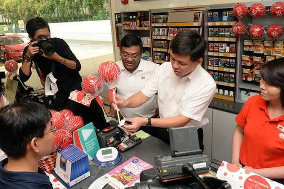 BOLA AMAL: Encik Chan melancarkan usaha mengumpul dana ComfortDelGro yang menghasilkan bebola berbusa merah yang dikenali sebagai 'titik merah', yang akan dijual bagi tujuan amal. - Foto THE STRAITS TIMES