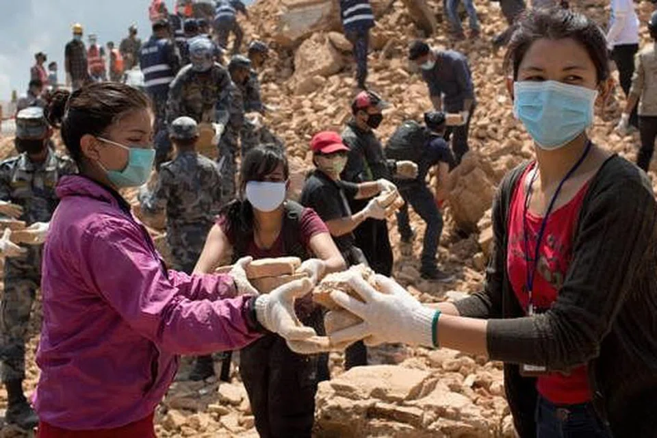 BERSIHKAN SAMPAH SARAP: Anggota polis dan orang awam membersihkan sampah sarap di kuil Narayan di Kathmandu dalam usaha mengelak wabak penyakit. - Foto AFP