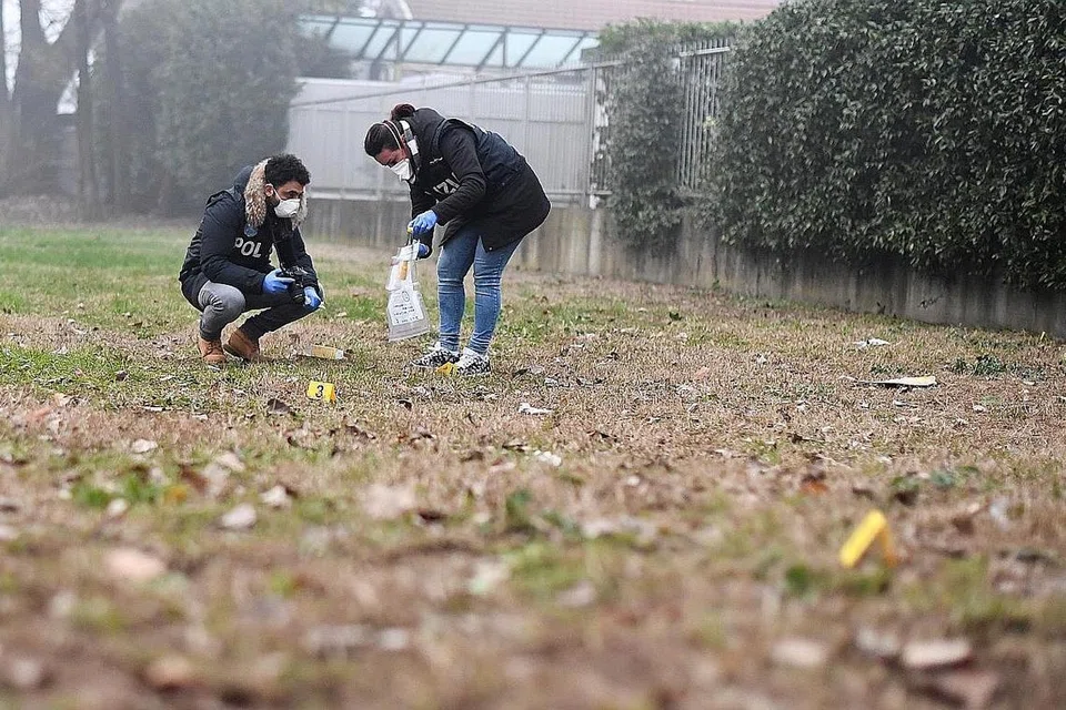 CARI BUKTI: Penyiasat forensik mencari bukti di sekitar tempat kejadian pergaduhan di mana seorang peminat Inter telah mati setelah dilanggar sebuah kenderaan. - Foto REUTERS