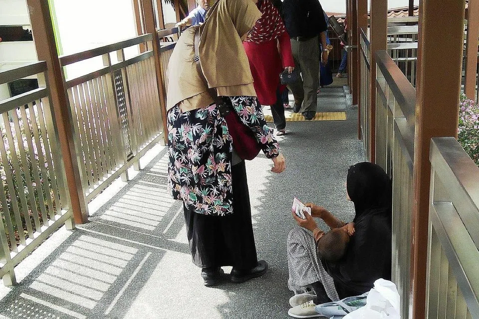 MENAGIH SIMPATI MASYARAKAT SINGAPURA: Wanita (atas) yang mendakwa dari India ini menghulur tangan meminta sedekah daripada pengunjung Pasar Geylang Serai, sementara seorang wanita dari Bangladesh mengemis di jejatas yang menghubungkan Joo Chiat Complex dan bangunan pasar itu sambil memangku anak kecilnya. - Foto-foto SAINI SALLEH