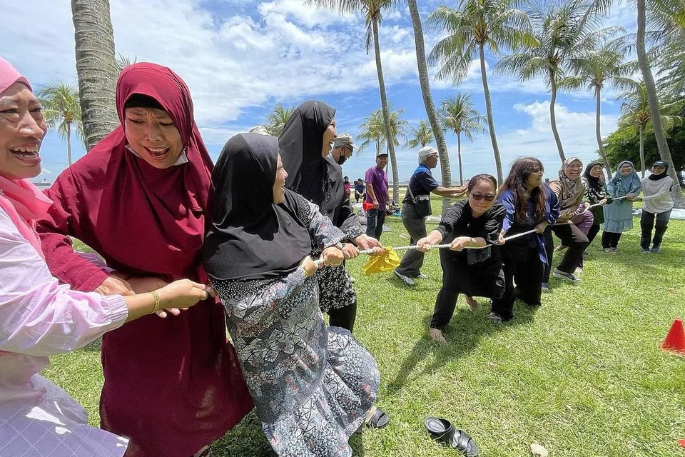 SERONOK BERMAIN: Selain menikmati jamuan yang dibawa, bekas penduduk Kampong Wak Kassim turut mengisi masa bersama dengan bermain permainan 'tarik tali' bagi mengembalikan kenangan ketika tinggal bersama di kampung. 