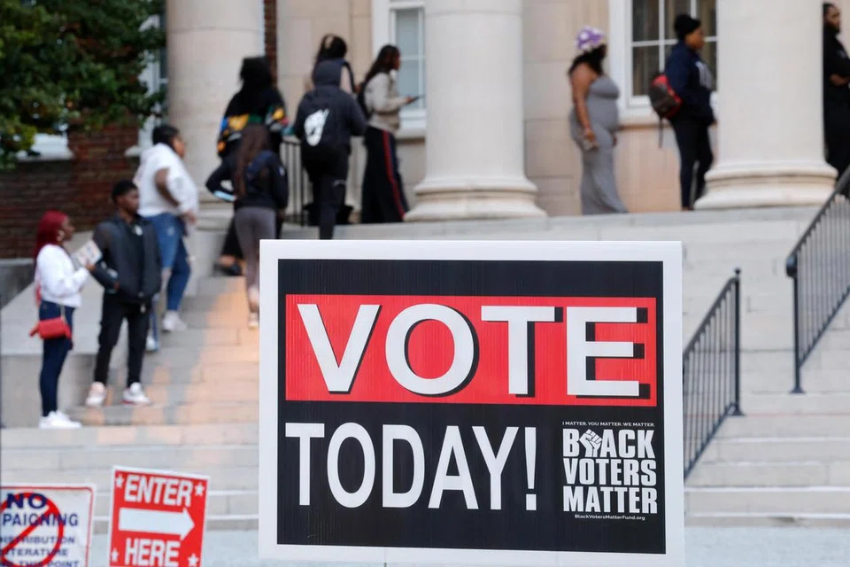 Pelajar di Universiti Pertanian dan Teknikal Negeri Carolina Utara (A&T) beratur untuk mengundi awal di kampus, berhampiran papan tanda bagi menggalakkan kaum kulit hitam mengundi, di Greensboro, Carolina Utara, Amerika Syarikat pada 28 Oktober.