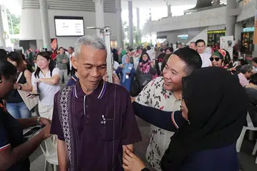 JALANI PEMERIKSAAN KESIHATAN: Seorang peserta acara Screen for a Screen di Kampong Admiralty Plaza semalam, Encik Mohamad Sadawi, mengambil ketinggian dan berat badannnya sambil diperhatikan Encik Amrin (dua dari kanan). - Foto BH oleh KELVIN CHNG