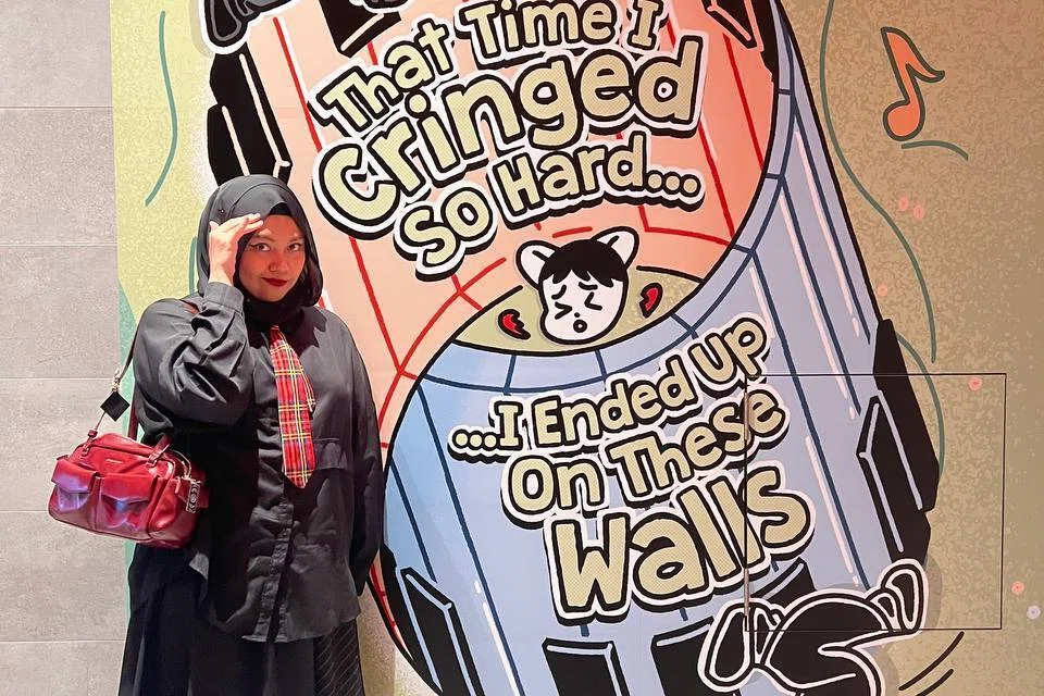 Nurjannah Suhaimi menjadikan komik sebagai wadah untuk menyentuh isu kesihatan mental dan keinsafan diri. Beliau berada di samping lukisan yang dapat dilihat di jambatan pejalan kaki bawah tanah Funan, berhampiran Funan Mall.