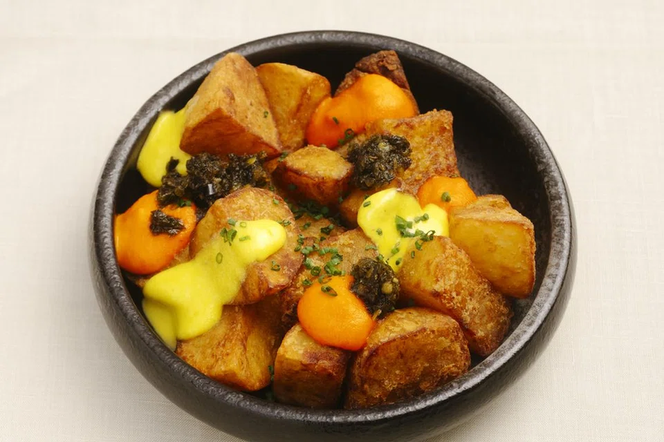 Hidangan Patatas Bravas  dihidangkan bersama sos kari bravas, aioli kunyit dan sambal hijau. 