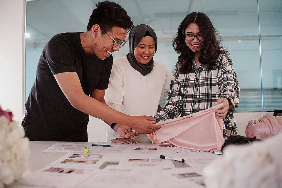 SENTUHAN PERIBADI: Cik Mariana (tengah) bersama dua perekanya sedang merancang pelamin dan hiasan sesuai berdasarkan cita rasa pelanggannya. - Foto BH oleh ONG WEE KIAT