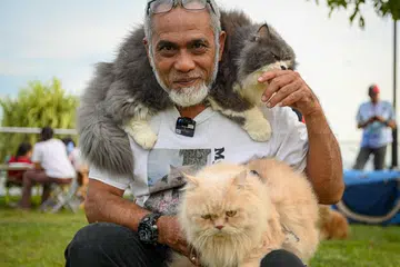 ‘CAT WHISPERER’:  Encik Khairizal Mohd Said menghimpunkan pemilik kucing di pantai East Coast setiap Sabtu. Beliau bergambar bersama dua ‘teman baiknya’ - Bumblebee dan Jerry (di bahunya). 