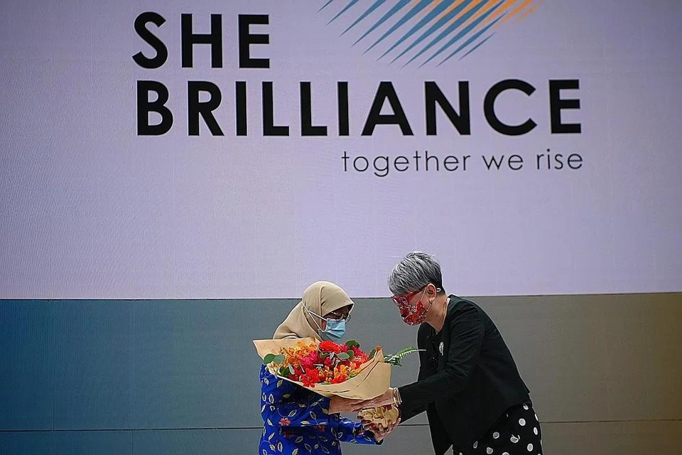 HARUS BANTU WANITA ELAK TEKANAN: Demikian gesa Presiden Halimah, yang kelihatan menerima jambangan bunga daripada Pengasas Bersama She Brilliance, Cik Kim Underhill, di bengkel pergerakan itu semalam. - Foto BH oleh MARK CHEONG