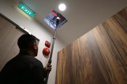 Seorang pegawai menggunakan batang ‘Q-stick’ yang menggunakan kamera definisi tinggi yang boleh berpusing 360 darjah. Alat itu membolehkan pengendali jalankan operasi mencari dengan selamat dan lebih cekap di kawasan yang susah dicapai seperti di atas almari tinggi. 