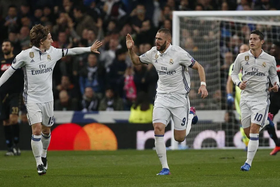 Karim Benzema (tengah) meraikan gol pertama yang dijaringkannya untuk Real Madrid, yang mengalahkan Napoli 3-1 dalam perlawanan peringkat 16 terakhir pertama mereka dalam Liga Juara-Juara di stadium Estadio Santiago Bernabeu pada Rabu (15 Feb). 