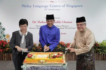 ULANG TAHUN:(Dari kiri) Timbalan Ketua Pengarah Pendidikan, Cik Chua Yen Ching, Menteri Kedua Pendidikan Dr Mohamad Maliki Osman dan Encik Mohamed Noh Daipi memotong kek bagi ulang tahun ke 10 MLCS. - Foto BH oleh GAVIN FOO