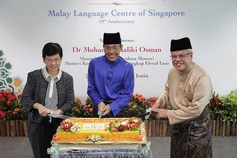 ULANG TAHUN:(Dari kiri) Timbalan Ketua Pengarah Pendidikan, Cik Chua Yen Ching, Menteri Kedua Pendidikan Dr Mohamad Maliki Osman dan Encik Mohamed Noh Daipi memotong kek bagi ulang tahun ke 10 MLCS. - Foto BH oleh GAVIN FOO