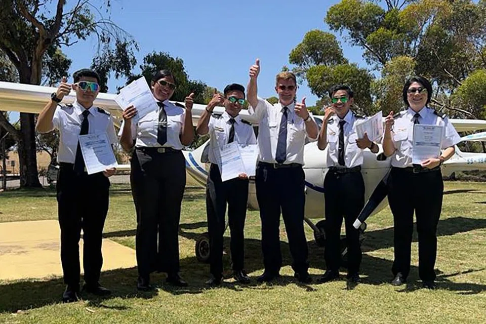 LESEN TERBANG: Encik Mohamed Hanafi (dua dari kanan) dan abangnya, Encik Mohamed Harith (tiga dari kiri), merupakan antara lima pelajar sekolah penerbangan Aeroviation Singapore yang meraih lesen penerbangan Sijil Juruterbang Rekreasi di Australia baru-baru ini. - Foto AEROVIATION SINGAPORE