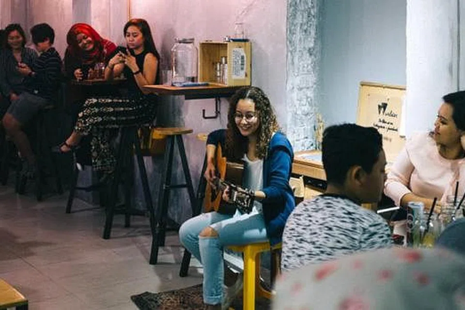 MENDENDANG LAGU CIPTAAN: Mariam Bamadhaj sedang mempersembah empat lagu asli tulisan dan gubahannya di Kafe Wilder pada Jumaat lalu. - Foto ihsan MARIAM BAMADHAJ