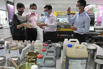 LAWAT FIRMA: (Dari kiri) Cik Josephine Teo, Encik Chan Chun Sing dan Encik Heng Swee Keat sedang meneliti bahan dari makmal firma binaan Samwoh Corporation semasa mengunjungi syarikat tersebut. Membimbing mereka dalam lawatan itu ialah Dr Kelvin Lee (paling kanan), pengurus teknisyen kanan Samwoh. - Foto BH oleh DESMOND FOO