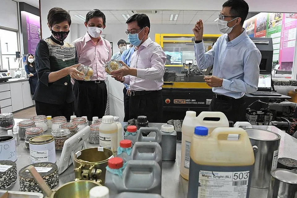 LAWAT FIRMA: (Dari kiri) Cik Josephine Teo, Encik Chan Chun Sing dan Encik Heng Swee Keat sedang meneliti bahan dari makmal firma binaan Samwoh Corporation semasa mengunjungi syarikat tersebut. Membimbing mereka dalam lawatan itu ialah Dr Kelvin Lee (paling kanan), pengurus teknisyen kanan Samwoh. - Foto BH oleh DESMOND FOO