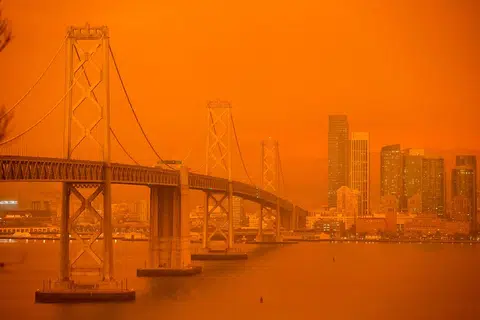 KESAN KEBAKARAN: Jambatan San Francisco Bay dan bangunan bandar diselubungi jerebu dan kabut jingga seperti yang dilihat dari Treasure Island di San Francisco, California pada 9 September 2020. - Foto AFP