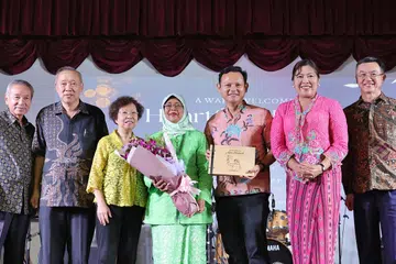 SUMBANGAN DIHARGAI: Puan Halimah Yacob (tengah) menerima buku dengan ukiran potretnya daripada Menteri Negara Kanan (Pertahanan merangkap Tenaga Manusia), Encik Zaqy Mohamad (empat dari kanan). Turut bergambar ialah isteri Encik Zaqy, Cik Haryane Mustajab (tiga dari kanan), serta anggota kanan badan akar umbi Marsiling (dari kiri) Encik Soon Tawn Tawin, Encik Cheong Khim Teck, Encik Lim Hock Chee, Cik Molly Too, Encik Shaw Kar Seng dan Encik Malik Maksudi, mantan penaung Jawatankuasa Perundingan Rakyat (CCC) Marsiling.