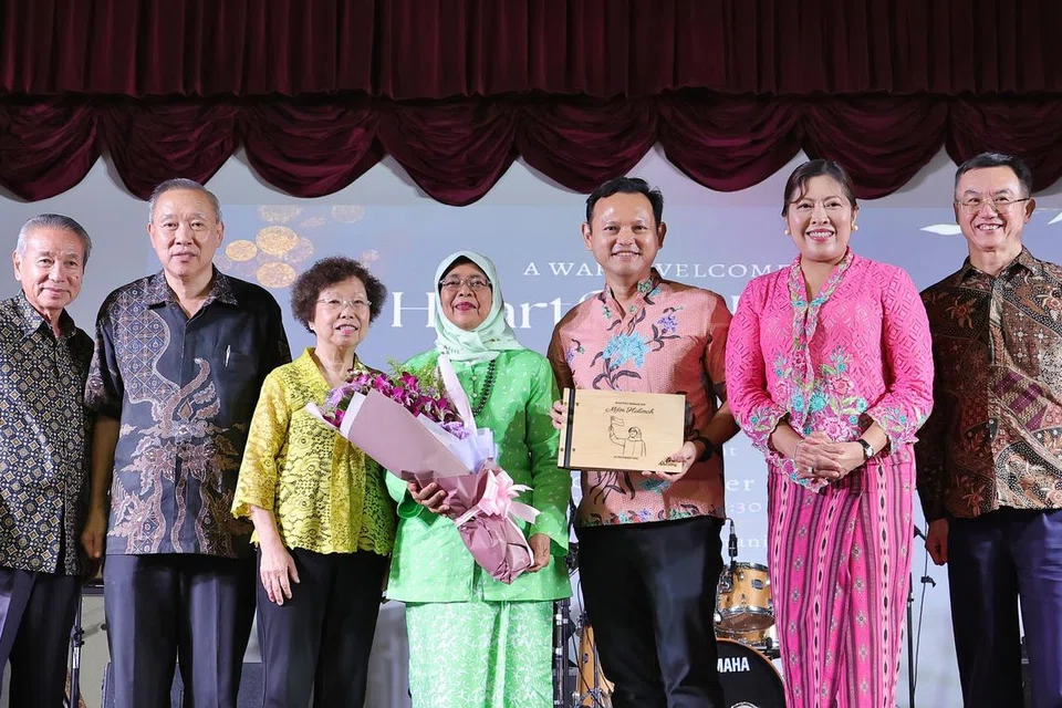 SUMBANGAN DIHARGAI: Puan Halimah Yacob (tengah) menerima buku dengan ukiran potretnya daripada Menteri Negara Kanan (Pertahanan merangkap Tenaga Manusia), Encik Zaqy Mohamad (empat dari kanan). Turut bergambar ialah isteri Encik Zaqy, Cik Haryane Mustajab (tiga dari kanan), serta anggota kanan badan akar umbi Marsiling (dari kiri) Encik Soon Tawn Tawin, Encik Cheong Khim Teck, Encik Lim Hock Chee, Cik Molly Too, Encik Shaw Kar Seng dan Encik Malik Maksudi, mantan penaung Jawatankuasa Perundingan Rakyat (CCC) Marsiling.