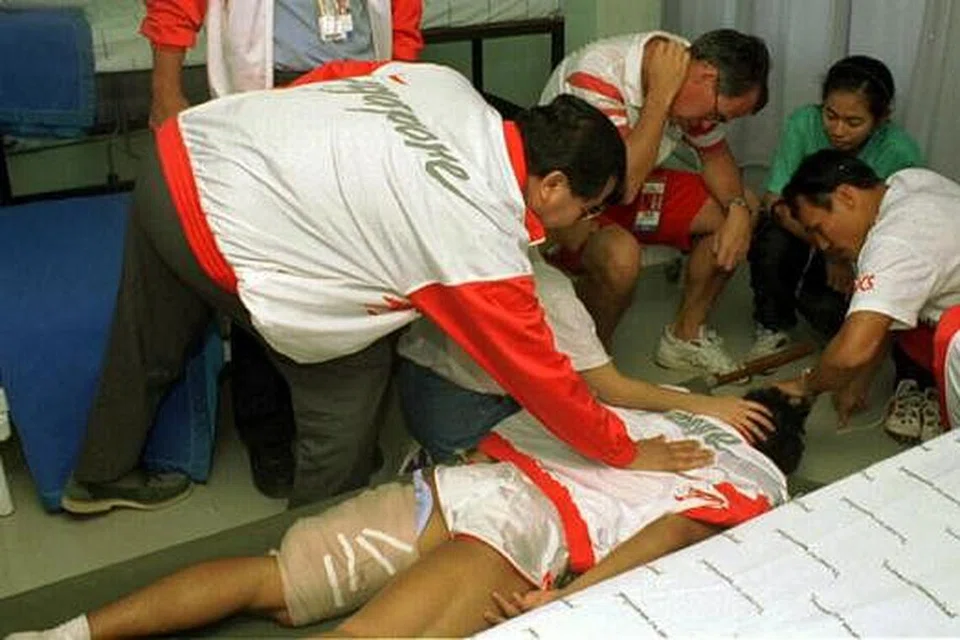 DETIK DUKA: Kecederaan akibat kejang otot paha menghalang Hamkah daripada mencapai impian memenangi pingat emas acara 200m Sukan SEA Chiangmai pada 1995 sehingga beliau terpaksa dipujuk oleh Encik Abdullah Tarmugi (kiri berjaket).