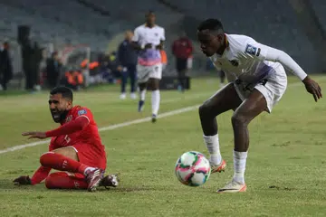 Pemain Tunisia, Ali Al-Abdi (kiri) terjatuh ketika cuba mendapatkan bola daripada pemain Namibia, Bethuel Muzeu, dalam perlawanan kelayakan Piala Dunia 2026 di Soweto pada 9 Jun. Perlawanan berakhir dengan keputusan seri tanpa jaringan.