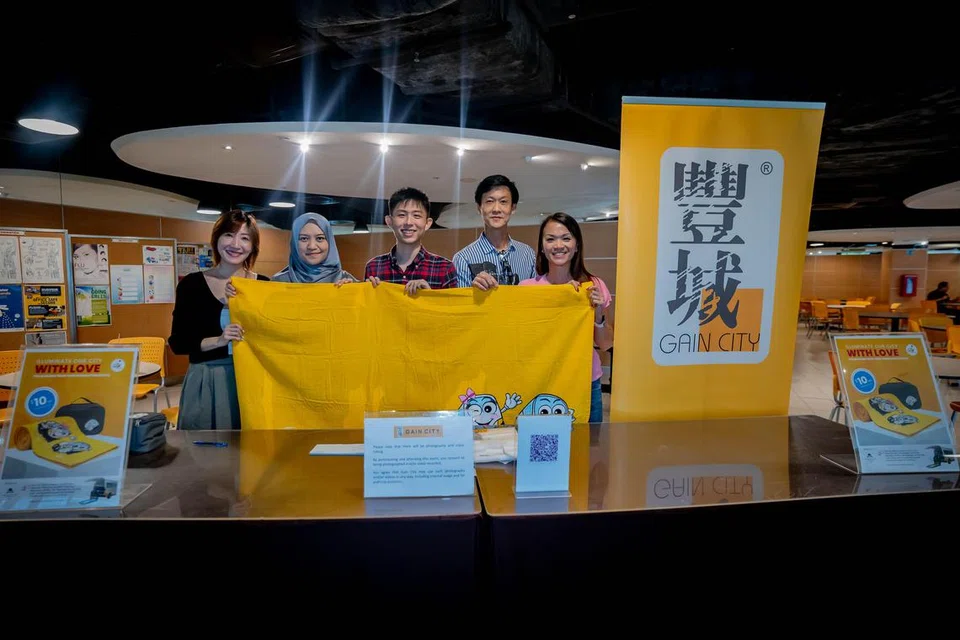 Cik Nur Asykin Ismail (dua dari kiri) dari Persatuan Dana Amanah Muslimin (MTFA) bersama kakitangan Gain City berjaya menjual 50 set beg serba guna dan tuala pantai dalam masa sejam di bangunan SPH Media pada 15 Mei.