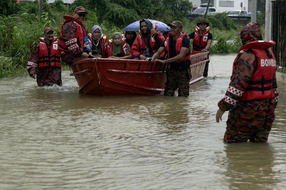 Anggota Bomba dan Penyelamat Malaysia Kelantan membantu memindahkan beberapa keluarga yang terperangkap selepas kediaman mereka di Taman Aspek, Tunjong, Kota Bharu, Kelantan, ditenggelami banjir pada 27 November.