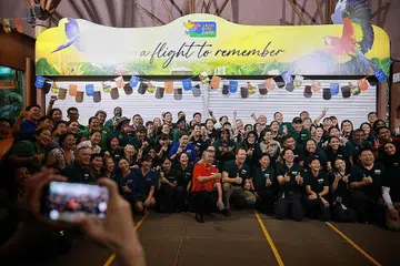 SELAMAT TINGGAL: Kakitangan Taman Burung Jurong mengambil gambar bersama di hadapan gerbang masuk taman itu yang telah ditutup sepenuhnya selepas satu majlis kelmarin. - Foto-foto BH oleh JASON QUAH