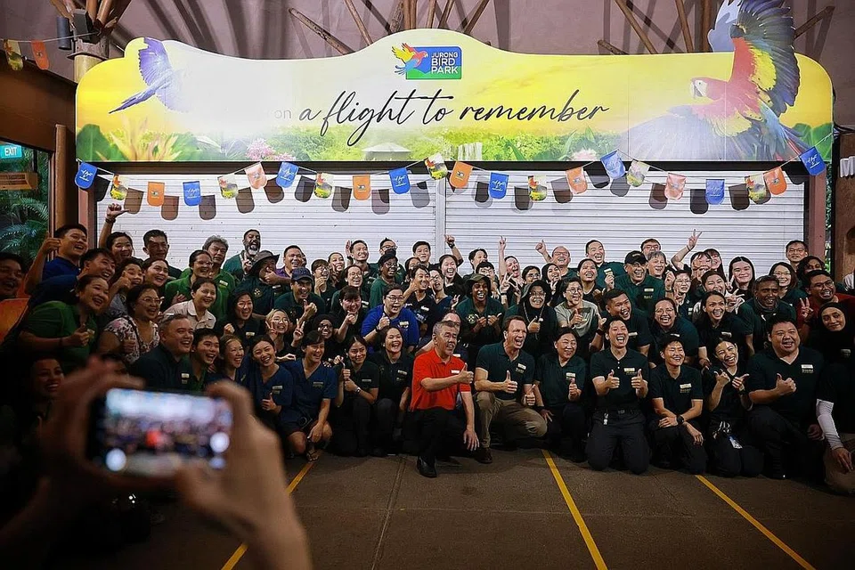 SELAMAT TINGGAL: Kakitangan Taman Burung Jurong mengambil gambar bersama di hadapan gerbang masuk taman itu yang telah ditutup sepenuhnya selepas satu majlis kelmarin. - Foto-foto BH oleh JASON QUAH
