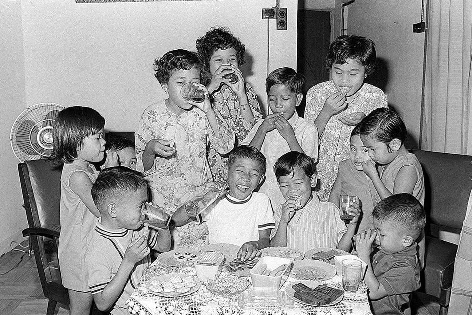 NOSTALGIA: Tahun 1970-an - GEMBIRANYA DAPAT MAKAN KUIH RAYA Kanak-kanak ini seronok minum oren dan makan pelbagai kuih-muih Raya dalam foto yang dipetik pada 1971. 