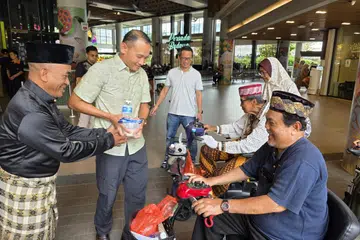 Mayor Majlis Pembangunan Masyarakat (CDC) South East, Encik Fahmi Aliman (dua dari kiri) dan pengerusi Jawatankuasa Eksekutif Kegiatan Melayu (MAEC) Geylang Serai, Encik Mohamed Zailani Mohamed Said (kiri) berinteraksi dengan pengunjung yang ke Wisma Geylang Serai.